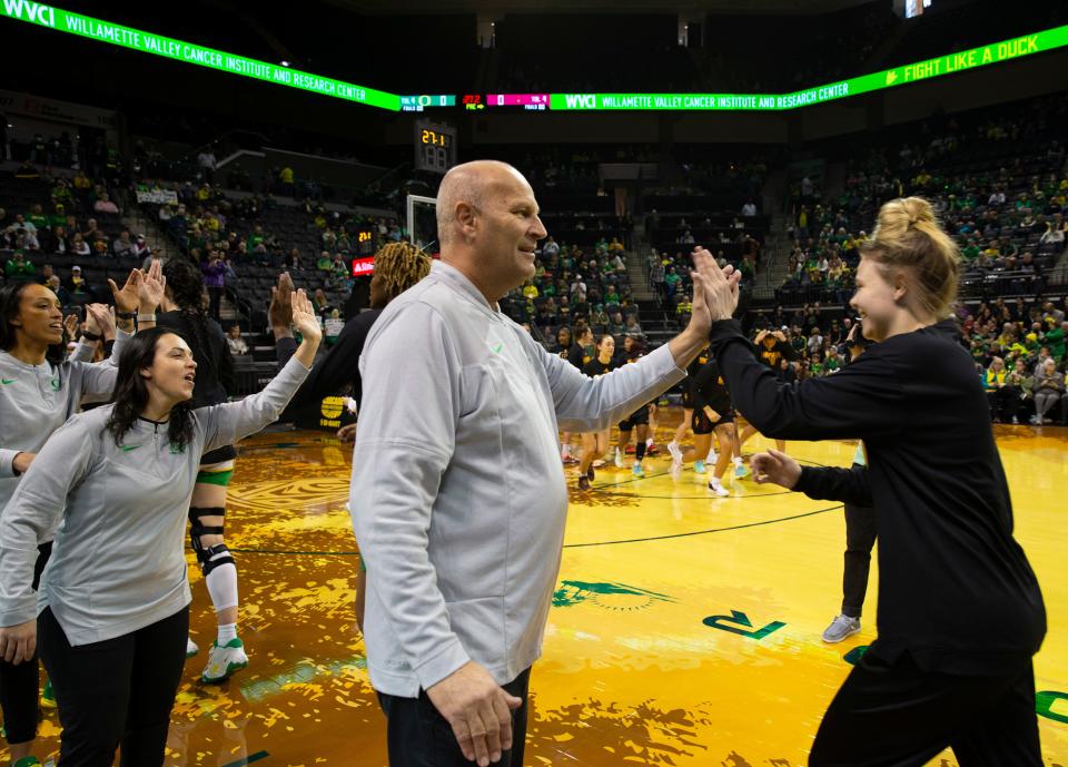 Oregon coach Kelly Graves, center, high-fives Sammie Wagner before the game against ASU at Matthew Knight Arena Feb. 25, 2023.