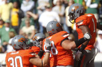 Oklahoma State running back Joseph Randle, right, celebrates with teammates following a touchdown against Baylor in the first quarter of an NCAA college football game in Stillwater, Okla., Saturday, Oct. 29, 2011. Randle set career-highs by running for 152 yards and four touchdowns as Oklahoma State won 59-24. (AP Photo/Sue Ogrocki)