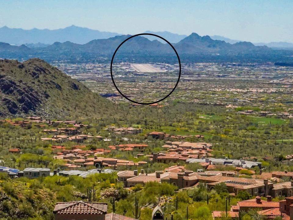 Mega mansions in the desert in Scottsdale with mountains in the background. A black circle highlights the Scottsdale airport