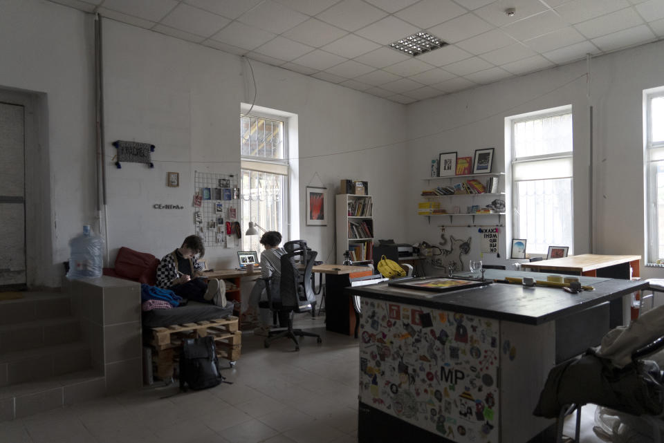 Anna Ivanenko, left, and Jenya Polosina, right, both Kyiv-based artists, work in their studio, in Kyiv, Ukraine, Sunday, April 30, 2023. Ivanenko and Polosina appeared Monday, May 1, 2023, from Kyiv via video link on a screen at an art opening for an exhibit called "Our Fire is Stronger Than Your Bombs" at Saint Anselm College, in Manchester, N.H., Monday, May 1, 2023. Ivanenko and Polosina are among a number of Ukrainian artists with works in the exhibit. (AP Photo/Vasilisa Stepanenko)
