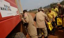 Firefighters fill their water bags during an operation to combat fires in Amazon jungle in Porto Velho