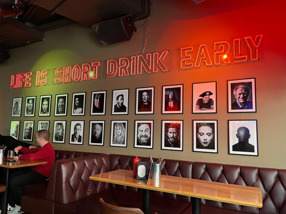 A neon sign reading "Life is short drink early" inside American Bar in Iceland.