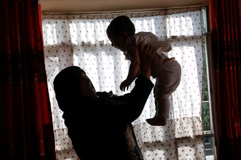 Golestan Safari, 45, plays with her granddaughter in her house in Kabul