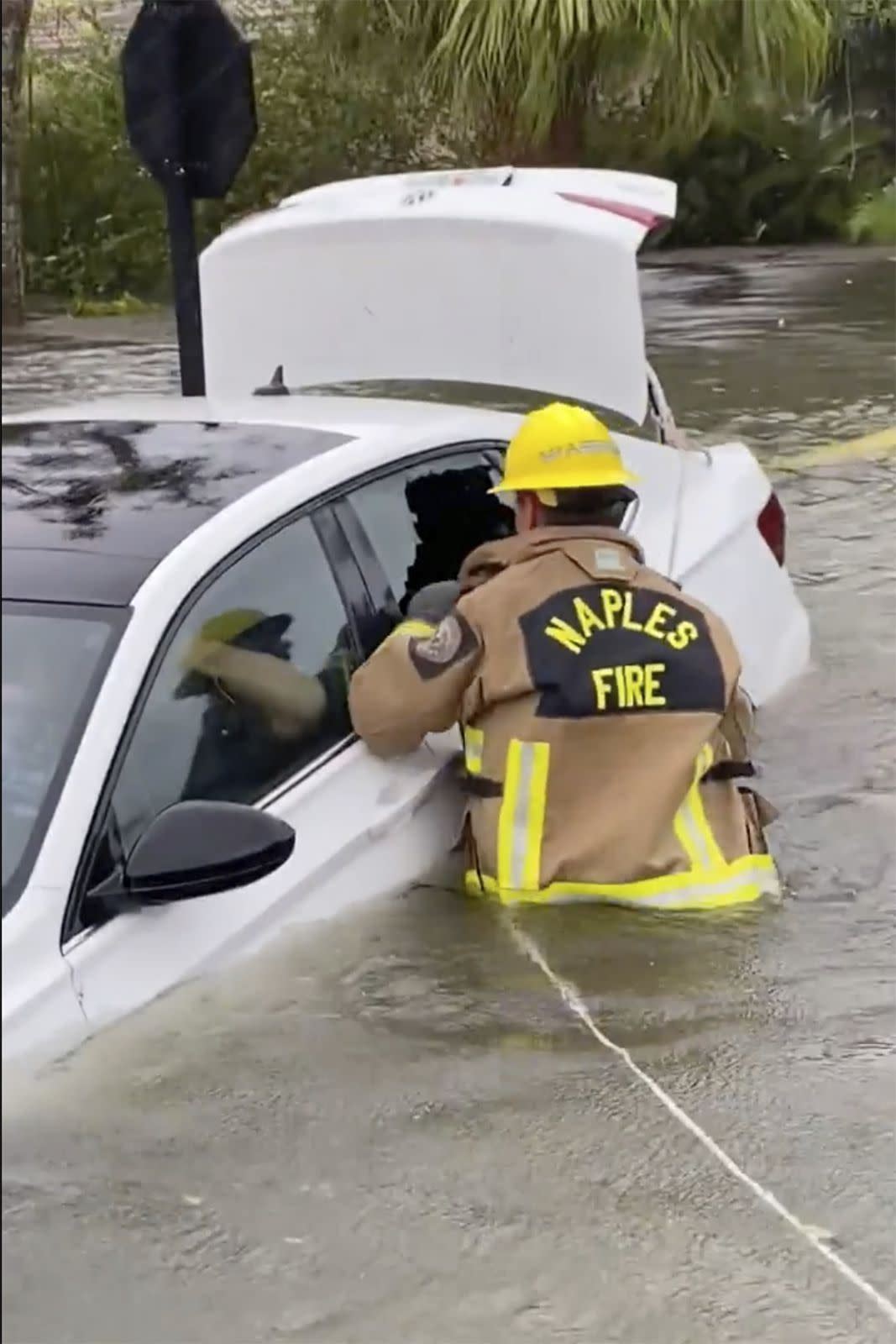 This photo provided by Naples Fire-Rescue Department crews help rescue a stranded motorist from flooding caused by Hurricane Ian on Wednesday, Sept. 28, 2022 in Naples, Fla. Officials say rain and overflow from rivers is causing severe flooding near parts of Florida’s Atlantic coast as storm Ian makes its way back out to sea.