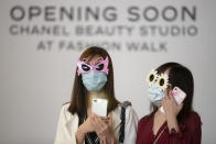 Women wearing masks and sunglasses attend a protest in Hong Kong, Friday, Oct. 18, 2019. Hong Kong pro-democracy protesters are donning cartoon and superhero masks as they formed a human chain across the semiautonomous Chinese city, in defiance of a government ban on face coverings. (AP Photo/Mark Schiefelbein)