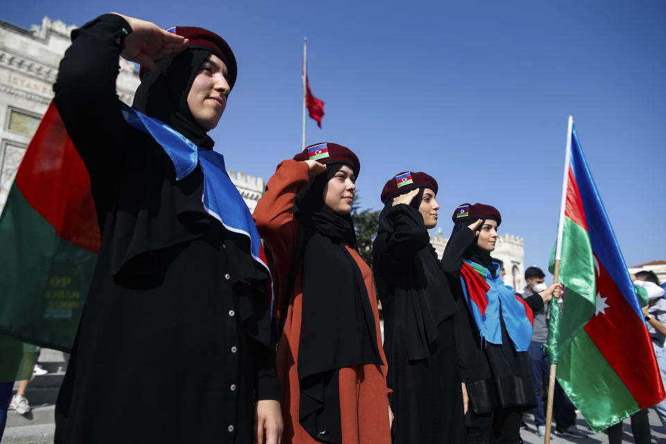 Demonstrators, wearing Turkish and Azerbaijani flags, saulte during a protest supporting Azerbaijan, in Istanbul, Sunday, Oct. 4, 2020. Armenian and Azerbaijani forces continue their fighting over the separatist region of Nagorno-Karabakh, following the reigniting of a decades-old conflict. Turkey, which strongly backs Azerbaijan, has condemned an attack on Azerbaijan's second largest city Gence and said the attack was proof of Armenia's disregard for law. (AP Photo/Emrah Gurel)