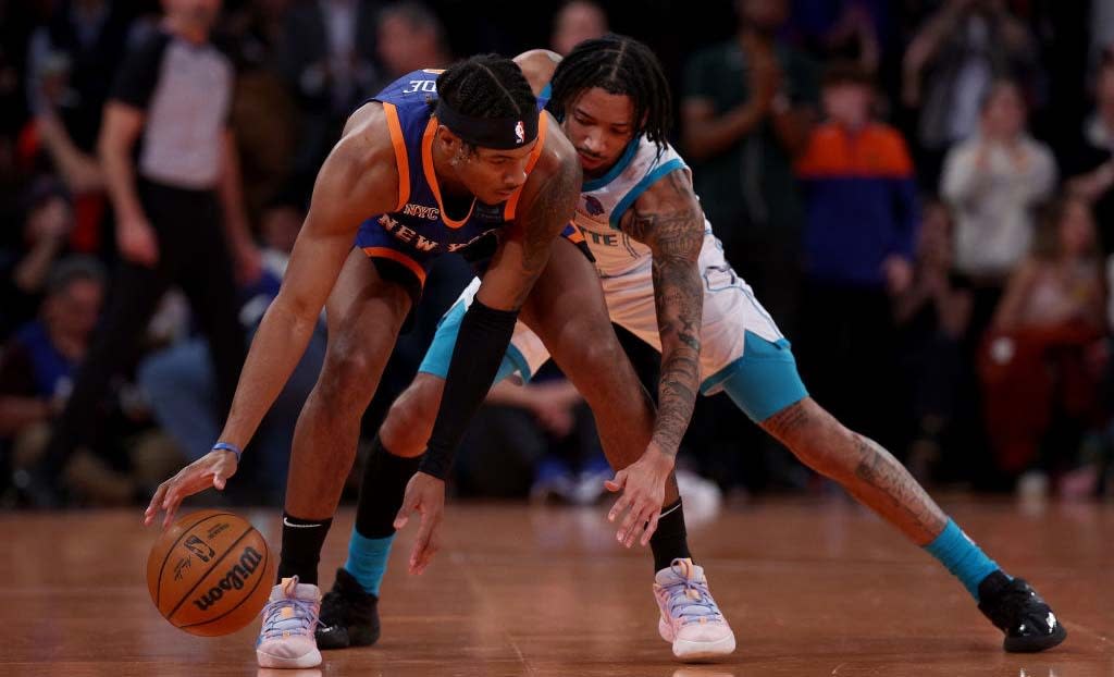  Miles McBride #2 of the New York Knicks runs out the clock as Nick Smith Jr. #8 of the Charlotte Hornets defends during the second half of an NBA In-Season Tournament game at Madison Square Garden on November 28, 2023. 