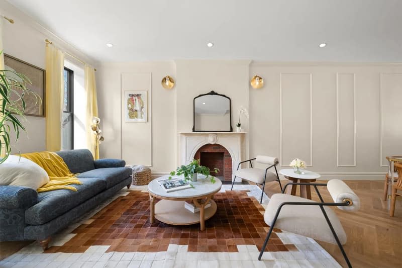 Gold sconces on either side of fireplace in newly renovated living room.