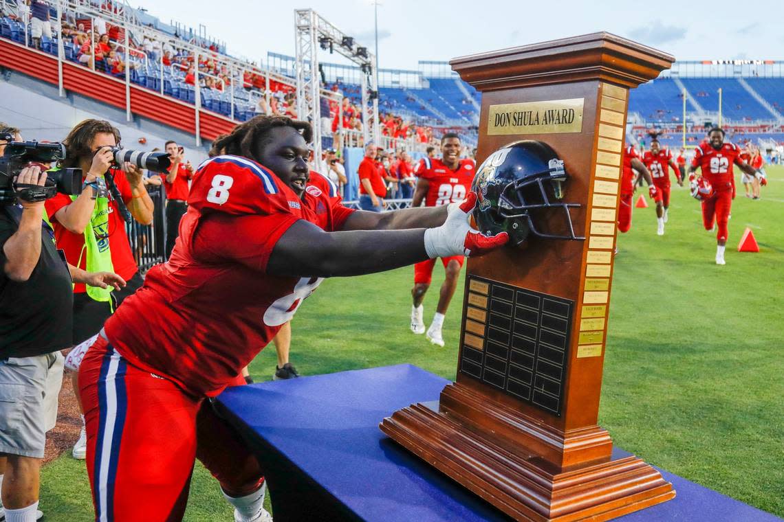Florida Atlantic Owls defensive lineman Evan Anderson (8) rips-off the Florida International University helmet from the Don Shula Award Trophy after winning the game at FAU Stadium in Boca Raton, Florida on Saturday, October 2, 2021.