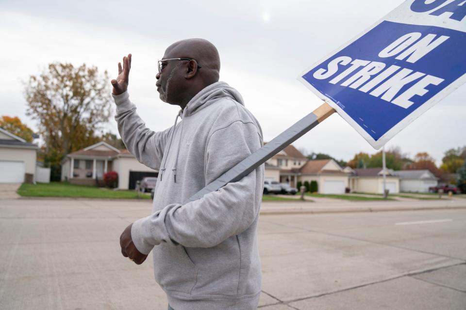 Tony Minus, 53, a hi lo operator at GM Pontiac Redistribution waves to well wishers as he works the picket line in Pontiac on Thursday, Oct. 26, 2023.