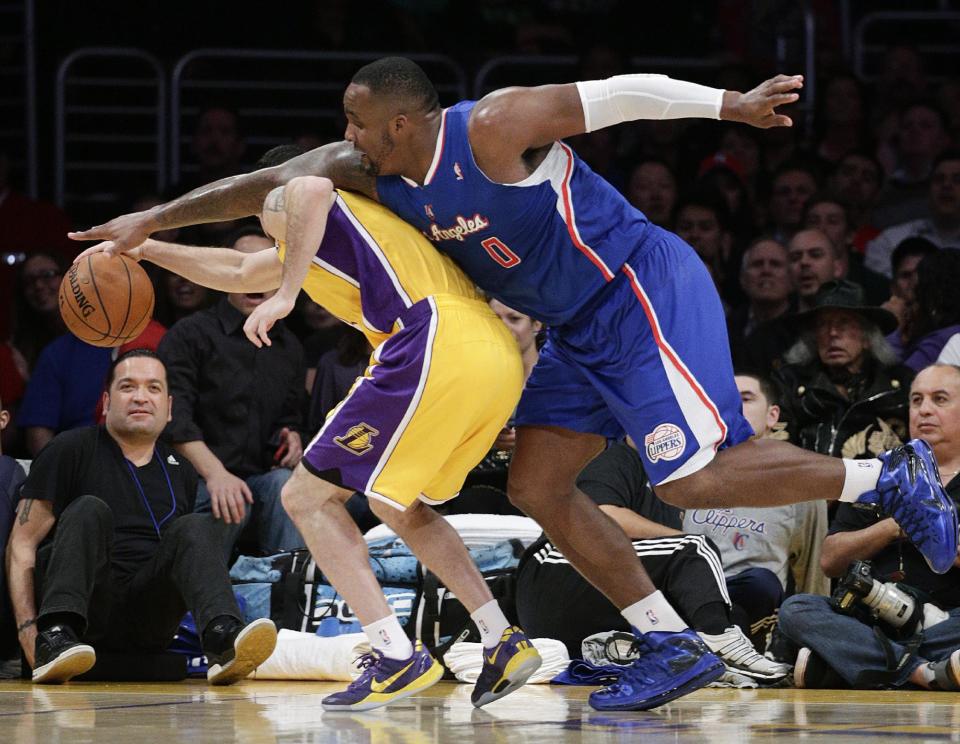 Los Angeles Clippers' Glen Davis, right, and Los Angeles Lakers' Jordan Farmar fight for a loose ball during the first half of an NBA basketball game on Thursday, March 6, 2014, in Los Angeles. (AP Photo/Jae C. Hong)