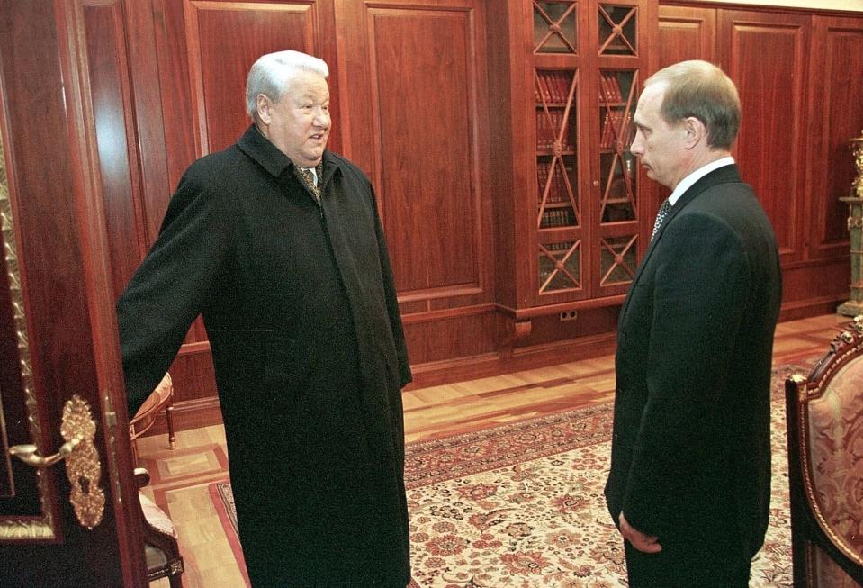 FILE - In this file photo taken on Friday, Dec. 31, 1999, former President Boris Yeltsin smiles as he holds a door before leaving his study as his successor, Vladimir Putin, listens in the Kremlin, in Moscow, Russia. (Sputnik, Kremlin Pool Photo via AP, File)