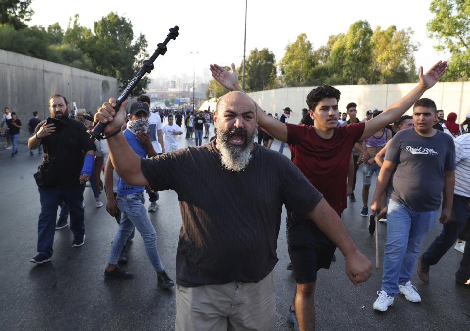 Anti-government protesters shout slogans during a protest against the Lebanese President Michel Aoun near the presidential palace, in Baabda east of Beirut, Lebanon, Saturday, Sept. 12, 2020. Lebanese soldiers on Saturday fired rubber bullets and live rounds in the air to disperse hundreds of protesters trying to march to the presidential palace during an anti-government demonstration. (AP Photo/Bilal Hussein)