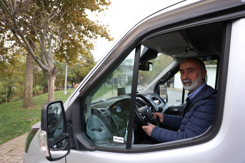 Ali Erdem, an Alevi faith leader known as dede, poses in his minibus parked in front of a cemevi in Istanbul