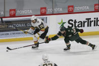 Minnesota Wild's Carson Soucy (21) tries to knock the puck away from Vegas Golden Knights' Ryan Reaves (75) in the third period of an NHL hockey game Monday, March 8, 2021, in St. Paul, Minn. (AP Photo/Stacy Bengs)