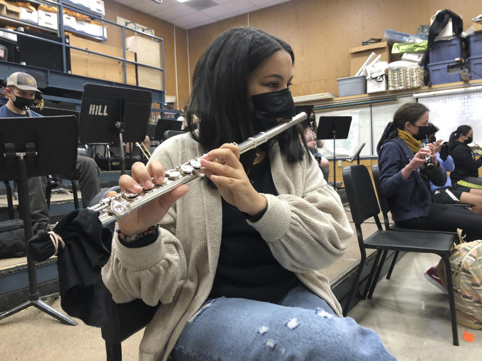 FILE - In this March 2, 2021 file photo, a student plays the flute while wearing a protective face mask during a music class at the Sinaloa Middle School in Novato, Calif. With COVID-19 cases soaring nationwide, school districts across the U.S. are yet again confronting the realities of a polarized country and the lingering pandemic as they navigate mask requirements, vaccine rules and social distancing requirements for the fast-approaching new school year. (AP Photo/Haven Daily)