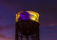 The historic 1928 Santa Ana water tower in Santa Ana, Calif., Monday, Jan. 27, 2020, is illuminated in purple and gold light in remembrance of Los Angeles Lakers legend Kobe Bryant. Bryant, the 18-time NBA All-Star who won five championships and became one of the greatest basketball players of his generation during a 20-year career with the Los Angeles Lakers, died in a helicopter crash Sunday. (Leonard Ortiz/The Orange County Register via AP)