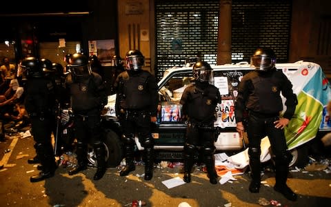  Spanish Civil Guards stand next to their damaged patrol car outside the Catalan region's economy ministry  - Credit: Reuters