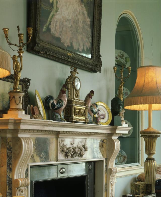 Two pink cockerels are among ornaments on the marble fireplace in the morning room at Clarence House (Alamy Stock Photo)