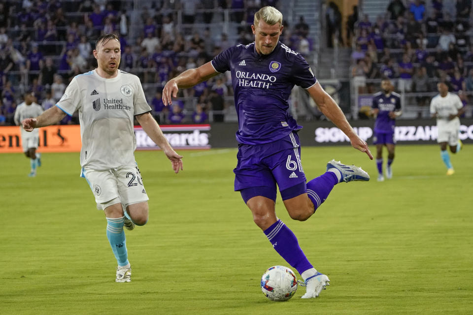 Orlando City's Robin Jansson (6) passes the ball as he is pressured by New England Revolution's Thomas McNamara, left, during the first half of an MLS soccer match Saturday, Aug. 6, 2022, in Orlando, Fla. (AP Photo/John Raoux)