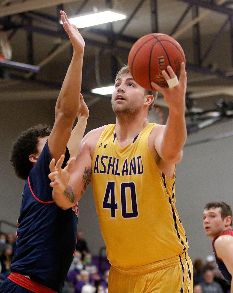 Ashland University's Derek Koch (40) puts up a shot against Malone University's Eli Ramsey during college men's basketball action Wednesday, Dec. 29, 2021 at Kates Gymnasium. TOM E. PUSKAR/TIMES-GAZETTE.COM