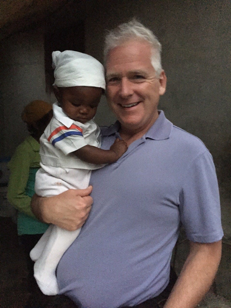 John Connolly, a Weymouth resident, holds a baby in Haiti on a mission trip in 2015.