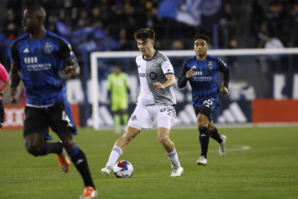 Toronto FC midfielder Alonso Coello, center, brings the ball up the field in front of San Jose Earthquakes midfielder Michael Baldisimo, right, during the second half of an MLS soccer match in San Jose, Calif., Saturday, March 25, 2023. (AP Photo/Josie Lepe)