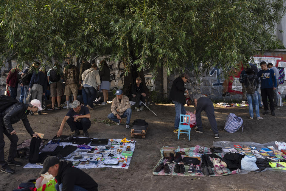 Varias personas compran en un mercadillo callejero en Kiev, Ucrania, el 9 de julio de 2023. El mercado ha sobrevivido a la guerra rusa en Ucrania, aunque los turistas han desaparecido y el nivel adquisitivo de la mayoría de los ucranianos ha bajado. (AP Foto/Jae C. Hong)