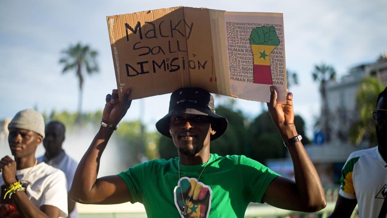  A protester is seen holding a placard during a protest against the dictatorship of Senegal's current president, Macky Sall, at Plaza de la Marina Square in Malaga 