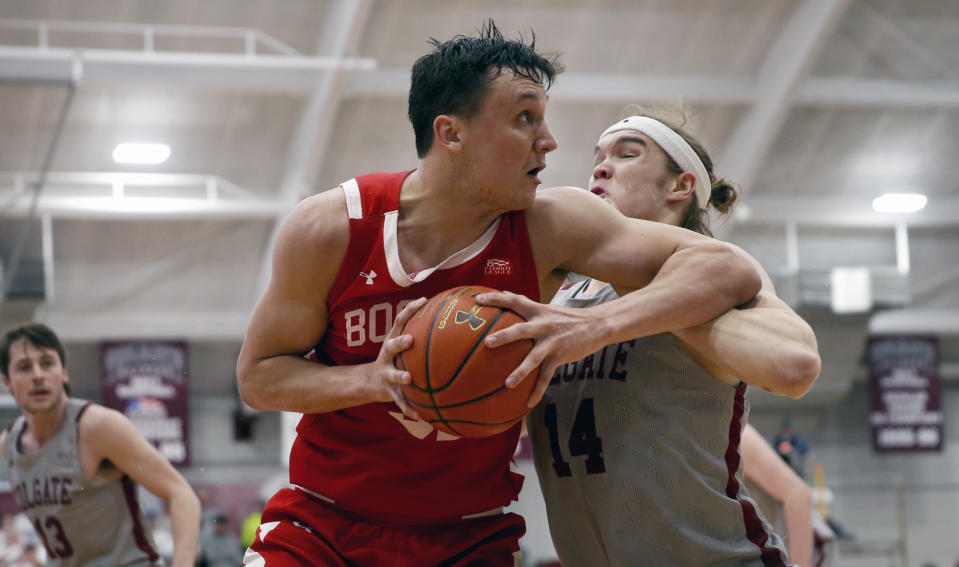 Boston University's Max Mahoney, left, drives past Colgate's Keegan Records, right during first half of the NCAA Patriot League Conference basketball tournament championship game at Cotterell Court, Wednesday, March 11, 2020, in Hamilton, N.Y. (AP Photo/John Munson)