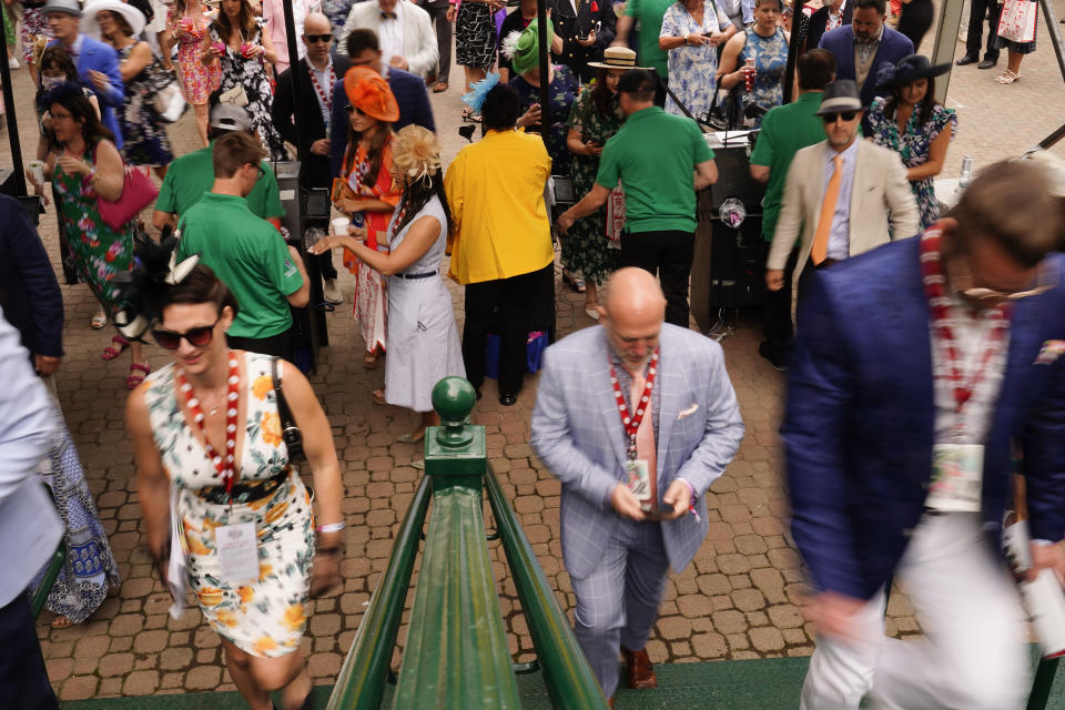 People walk on the grounds of Churchill Downs before the 149th running of the Kentucky Derby horse race Saturday, May 6, 2023, in Louisville, Ky. (AP Photo/Brynn Anderson)