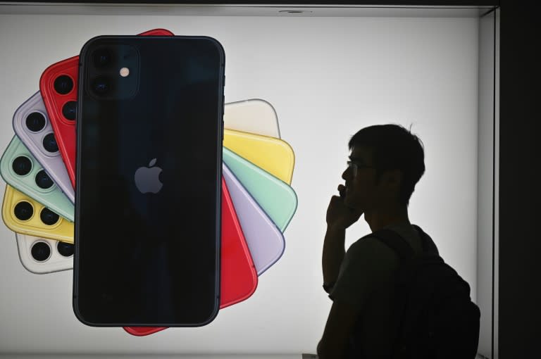 Un hombre habla por teléfono al pasar por delante de un anuncio del nuevo iPhone en una tienda de Apple en Hong Kong el 10 de octubre de 2019. Foto: AFP. 