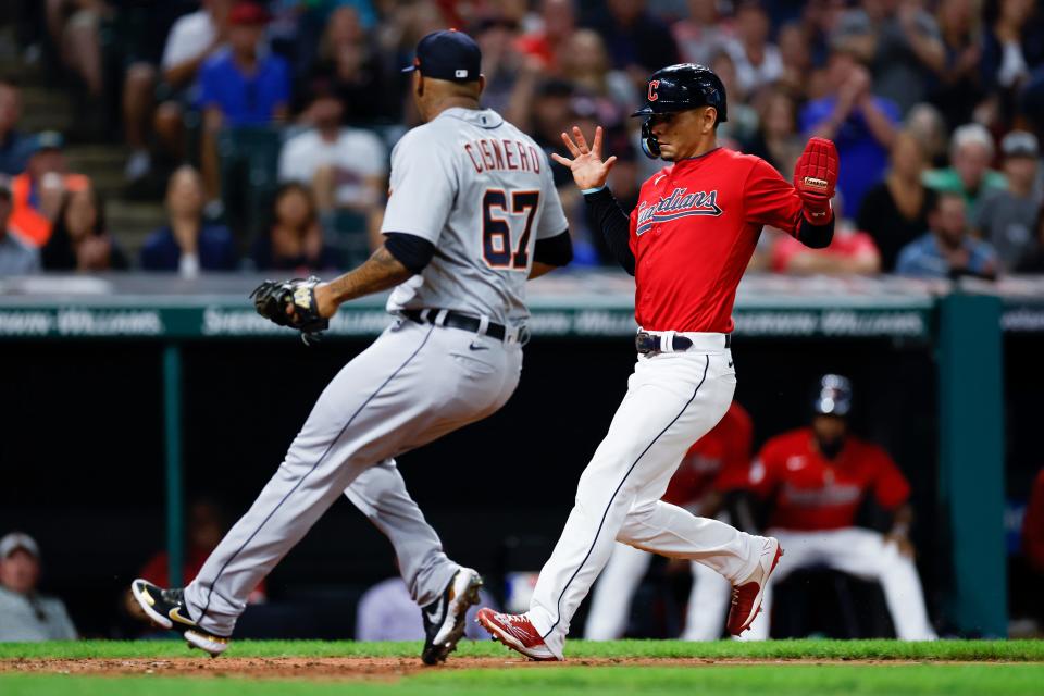 Cleveland Guardians' Andres Gimenez, right, scores past Detroit Tigers relief pitcher Jose Cisnero on a passed ball by catcher Eric Haase during the sixth inning of a baseball game Wednesday, Aug. 17, 2022, in Cleveland. (AP Photo/Ron Schwane)