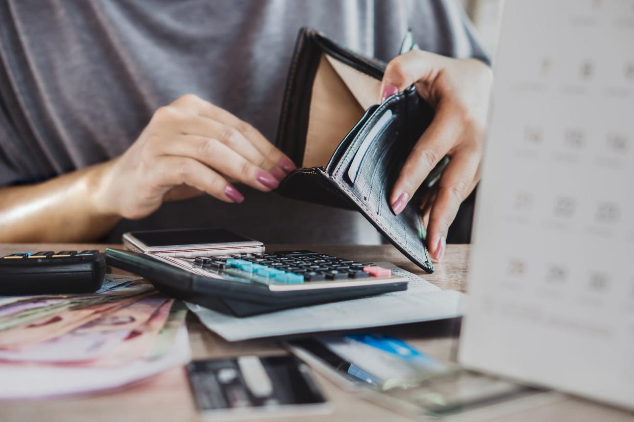 woman hand open empty purse looking for money for credit card debt, bankrupt concept