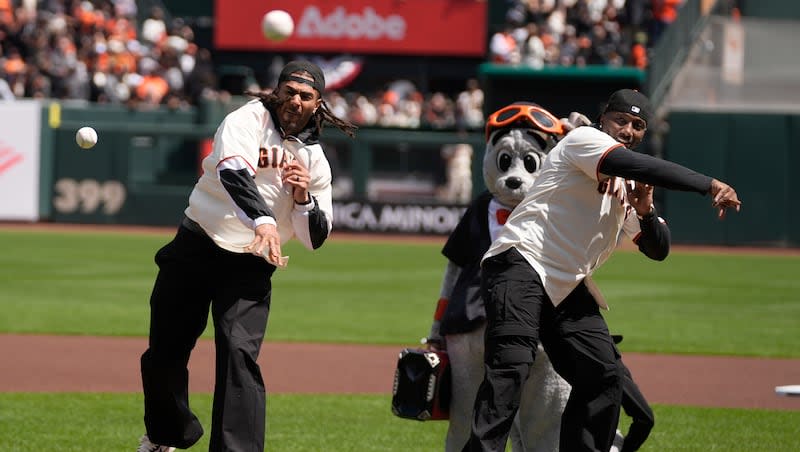 San Francisco 49ers football players Fred Warner, left, and Deebo Samuel throw out ceremonial first pitches before a baseball game between the San Francisco Giants and the San Diego Padres in San Francisco, Friday, April 5, 2024. (AP Photo/Eric Risberg)