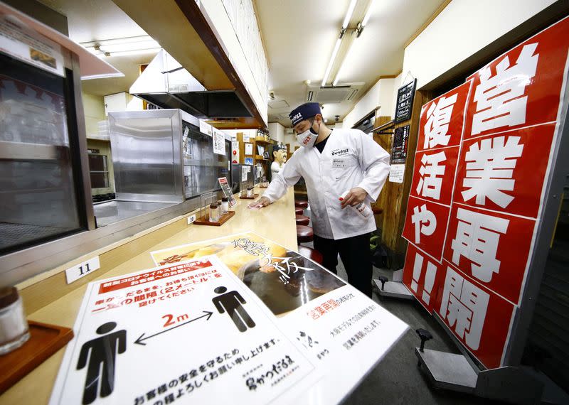 An employee of a restaurant disinfects the counter as they prepare to resume their business during the spread of the coronavirus disease (COVID-19) continues, in Osaka, Japan