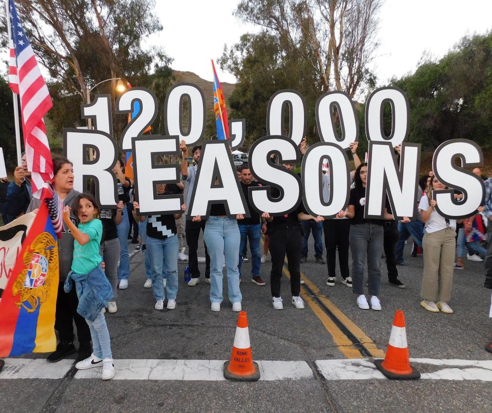 Participants in a rally Tuesday near the Ronald Reagan Presidential Library & Museum in Simi Valley hold up signs in support of the 120,000 ethnic Armenians they say are being hurt by Azerbaijan.