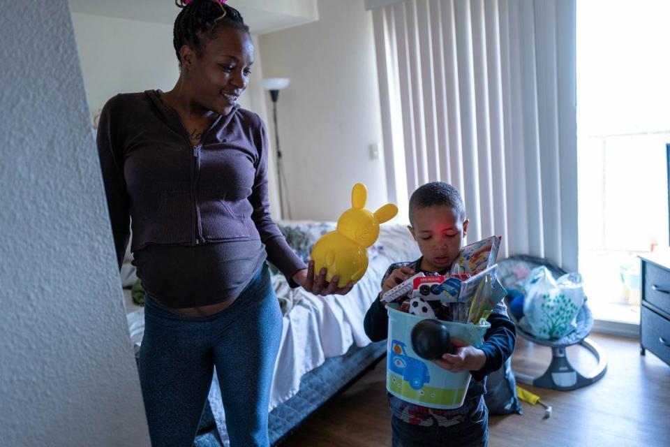 Marquisha Brown and her son Eliijah sort through some of his possessions at home last month. Brown said the Yolo Basic Income program has allowed her to provide him things that she couldn’t while they were homeless.