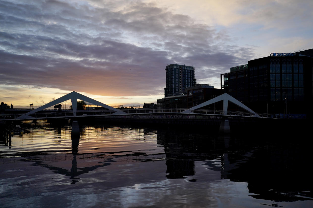 The sun begins to rise over the River Clyde outside the venue of the COP26 U.N. Climate Summit in Glasgow, Scotland, Tuesday, Nov. 2, 2021. The U.N. climate summit in Glasgow gathers leaders from around the world, in Scotland's biggest city, to lay out their vision for addressing the common challenge of global warming. (AP Photo/Alberto Pezzali)