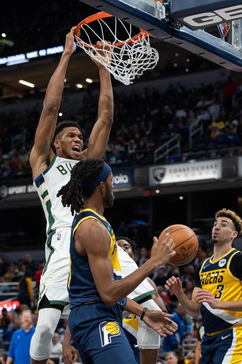 Nov 28, 2021; Indianapolis, Indiana, USA; Milwaukee Bucks forward Giannis Antetokounmpo (34) slam dunks the ball while Indiana Pacers forward Isaiah Jackson (23) defends  in the second half at Gainbridge Fieldhouse. Mandatory Credit: Trevor Ruszkowski-USA TODAY Sports