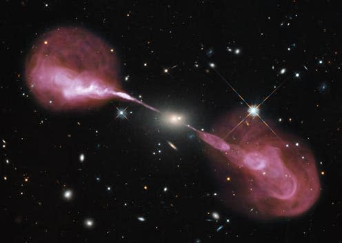 <span class="caption">Visible light image of the radio galaxy Hercules A obtained by the Hubble Space Telescope superposed with a radio image taken by the Very Large Array of radio telescopes in New Mexico, USA.</span> <span class="attribution"><span class="source">NASA</span></span>