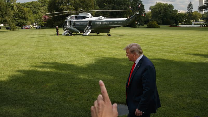 A reporter tries to get the attention of President Donald Trump as the president finishes speaking to the media about the Congressional testimony of former special counsel Robert Mueller, Wednesday, July 24, 2019, on the South Lawn of the White House in Washington.