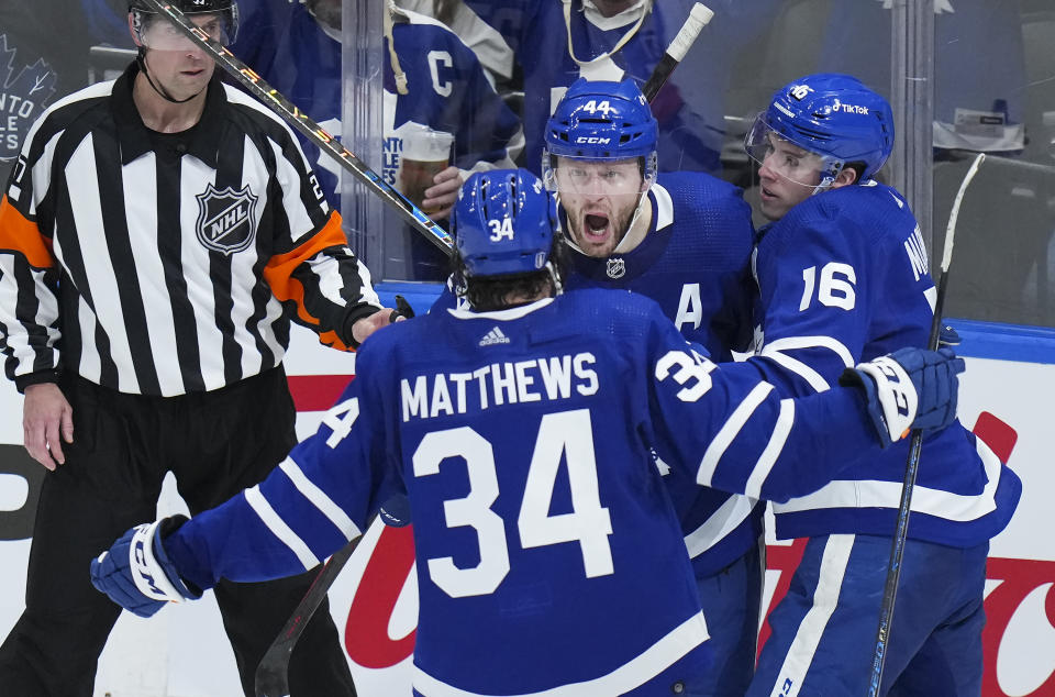 Toronto Maple Leafs defenseman Morgan Rielly (44) celebrates his goal with teammates Auston Matthews (34) and Mitchell Marner (16) while playing against the Tampa Bay Lightning during the second period of Game 7 in an NHL hockey first-round playoff series in Toronto,Saturday, May 14, 2022. (Nathan Denette/The Canadian Press via AP)