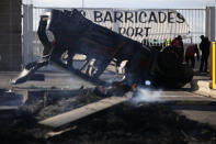 An overturned car is pictured during a blockade in the Mediterranean port city in Marseille, southern France, Thursday, Dec.12, 2019. Unions have flatly rejected fresh proposals by the government of pro-business President Emmanuel Macron to stagger the roll-out of a plan that would require France's youngest workers - people born after 1974 - to stay on the job until the age of 64 to get full pensions instead of age 62. (AP Photo/Daniel Cole)