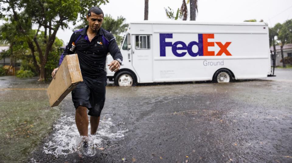 FedEx driver Rico Torres, 33, delivers a package to a home as heavy rain falls over parts of South Florida on Wednesday, June 12, 2024, in Hollywood, Fla. (Matias J. Ocner/Miami Herald via AP)