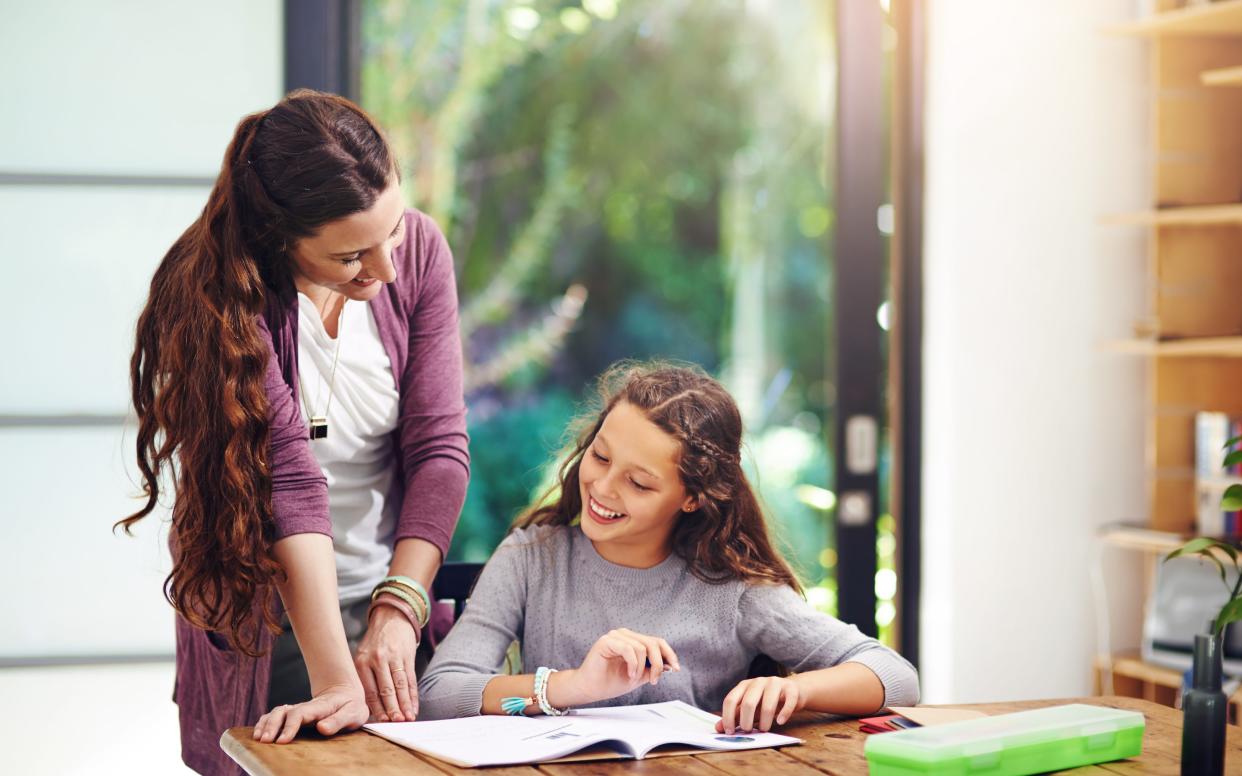 mother and daughter look at book - PeopleImages