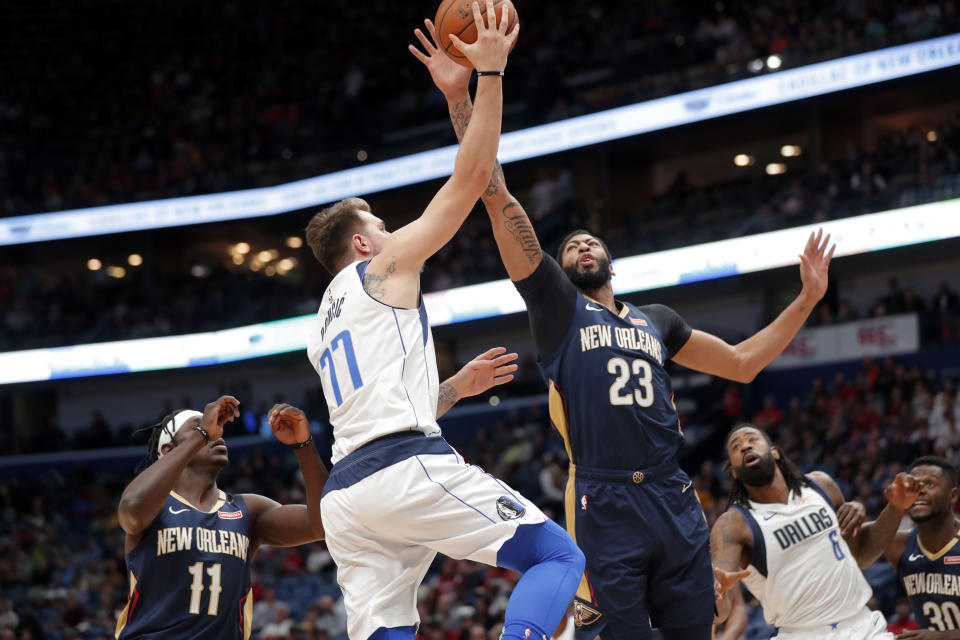Dallas Mavericks forward Luka Doncic (77) goes to the basket against New Orleans Pelicans forward Anthony Davis (23) during the first half of an NBA basketball game in New Orleans, Friday, Dec. 28, 2018. (AP Photo/Gerald Herbert)