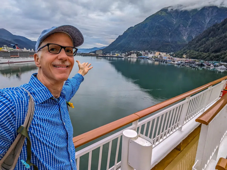 Michael on a cruise ship deck gesturing at Juneau