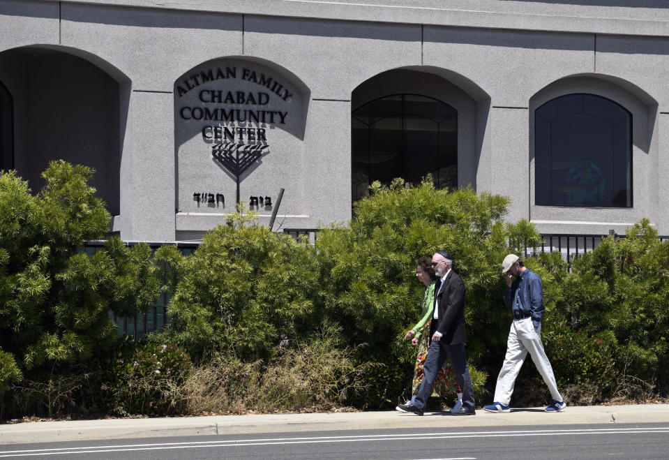 FILE - In this April 27, 2019 file photo, synagogue members walk outside of the Chabad of Poway Synagogue in Poway, Calif. The gunman who attacked the synagogue last week fired his semi-automatic rifle at Passover worshippers after walking through the front entrance that synagogue leaders identified last year as needing improved security. The synagogue applied for a federal grant to better protect that area. The money, $150,000, was approved in September but only arrived in late March. "Obviously we did not have a chance to start using the funds yet," Rabbi Scimcha Backman told The Associated Press. (AP Photo/Denis Poroy)