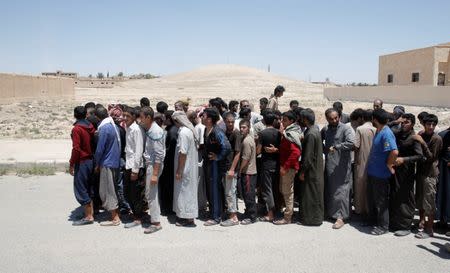 Islamic State prisoners, who were pardoned by a council that is expected to govern Raqqa once the group is dislodged from the Syrian city, stand in Ain Issa village, north of Raqqa, Syria June 24, 2017. REUTERS/Goran Tomasevic